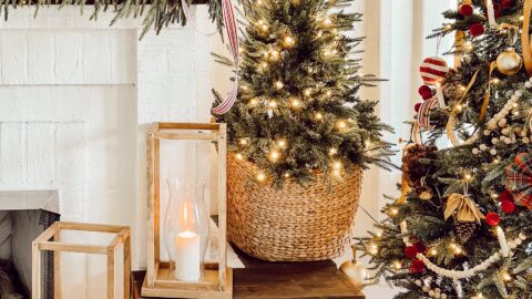 Christmas trees with presents and lanterns around fireplace