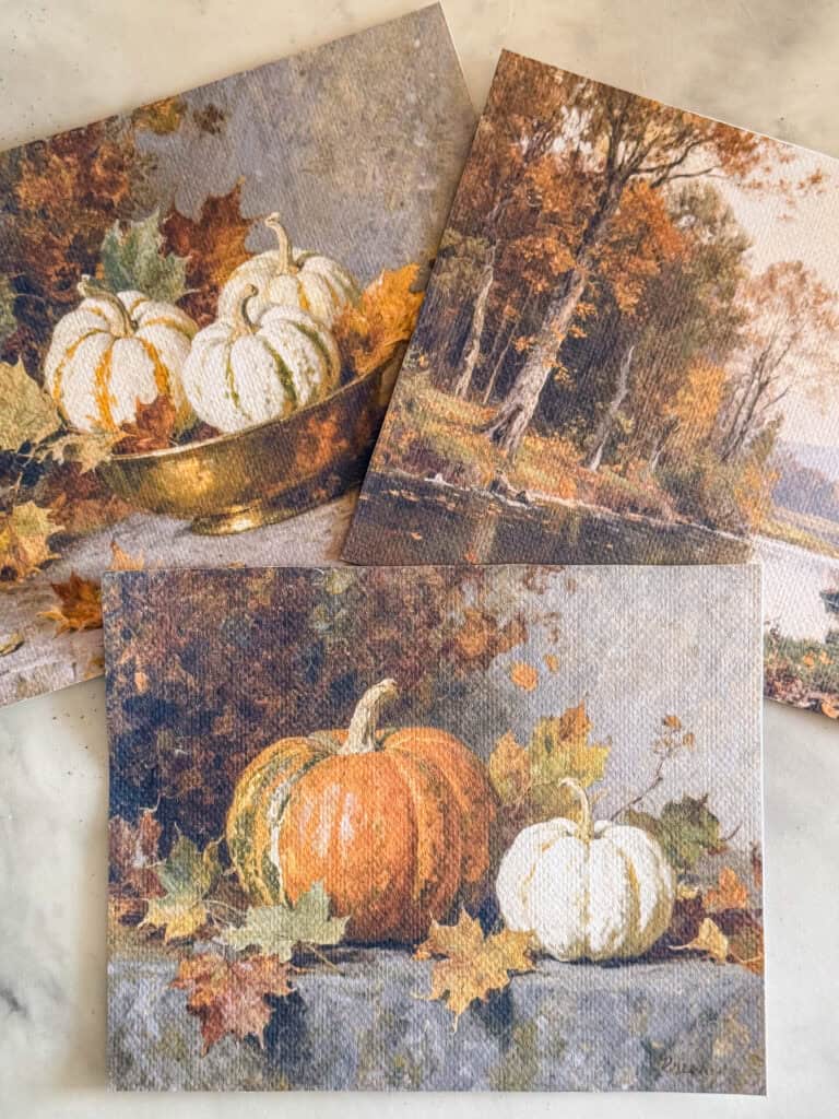 Three autumn-themed cards featuring pumpkins and fall leaves. One card shows white pumpkins in a bowl, another depicts a landscape with trees and a lake, and the third has orange and white pumpkins with leaves.